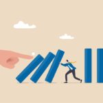 ilustração de um homem segurando placas, como dominos, e uma mão empurando as peças. Representando riscos